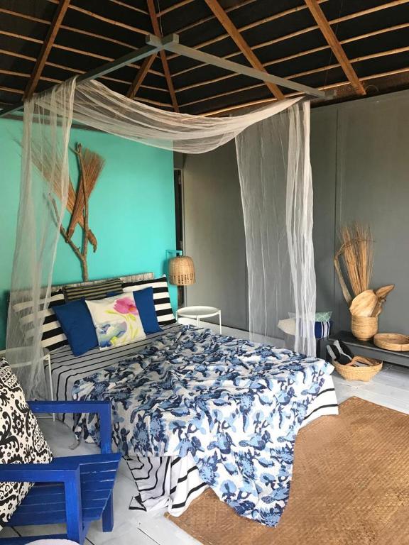 a bedroom with a bed with a blue wall at Turtle Hill Patnem in Canacona