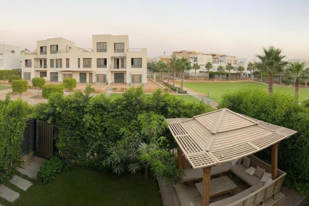 an umbrella sitting on top of a yard with houses at Elegant 3-Floor Villa with Private Garden in Westown, SODIC Beverly Hills, Sheikh Zayed in Sheikh Zayed