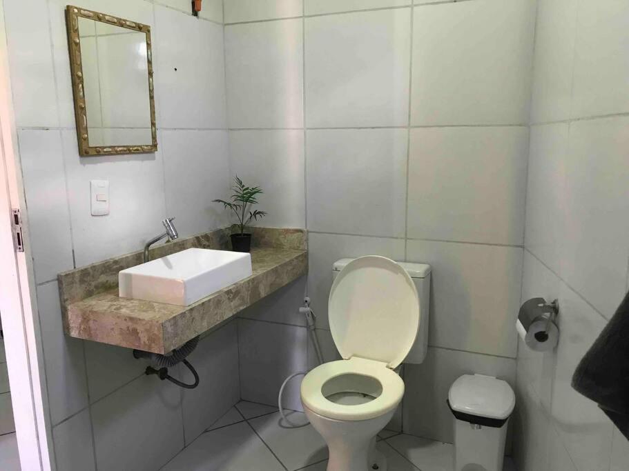 une salle de bain blanche avec toilettes et lavabo dans l'établissement Flecheirasapê, à Flecheiras