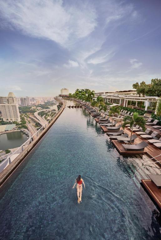 eine Person, die im Wasser am Infinity-Pool eines Resorts steht in der Unterkunft Marina Bay Sands in Singapur