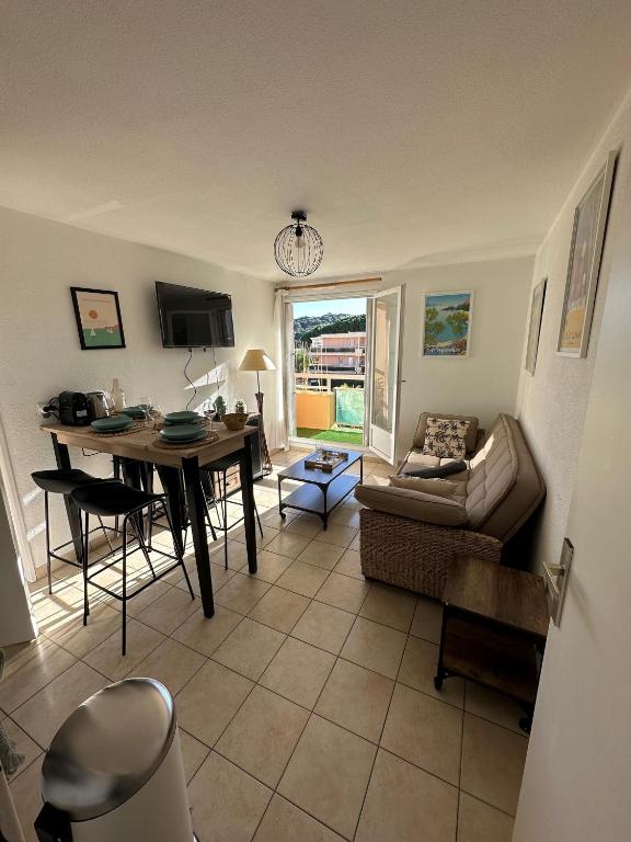 un salon avec une table et un canapé dans l'établissement T2 cabine tout équipé, 300m mer, à Bormes-les-Mimosas