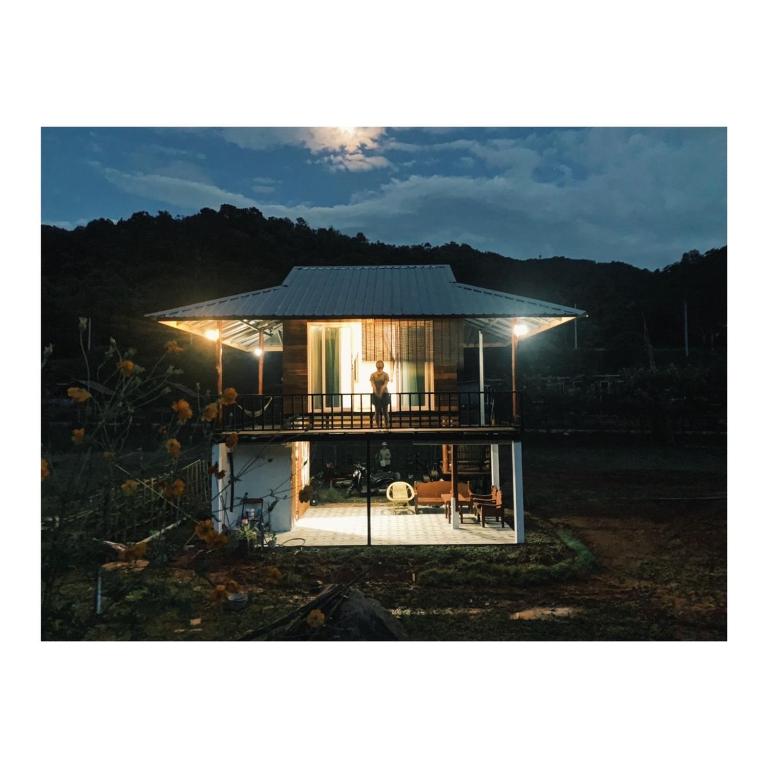 a man standing on the deck of a tiny house at บ้านนาสลี cottage บ่อเกลือ in Ban Pha Khap