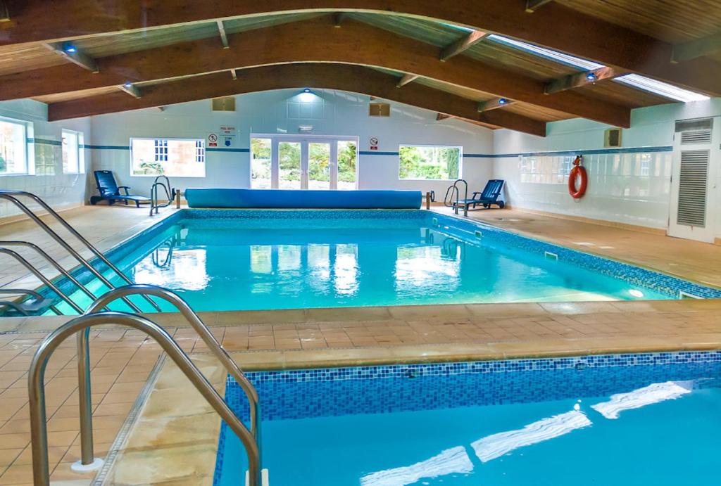 a large swimming pool with blue water in a building at Kilconquhar Castle Estate in Kilconquhar