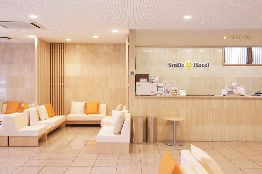 a lobby of a smile hospital with couches and a counter at Smile Hotel Sugamo in Tokyo