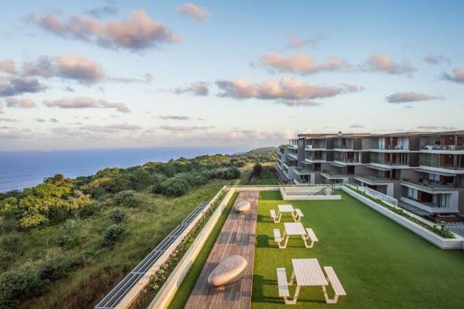 an aerial view of a building with tables and chairs at Luxury Apartment in Pebble Beach Umhlanga in Umhlanga