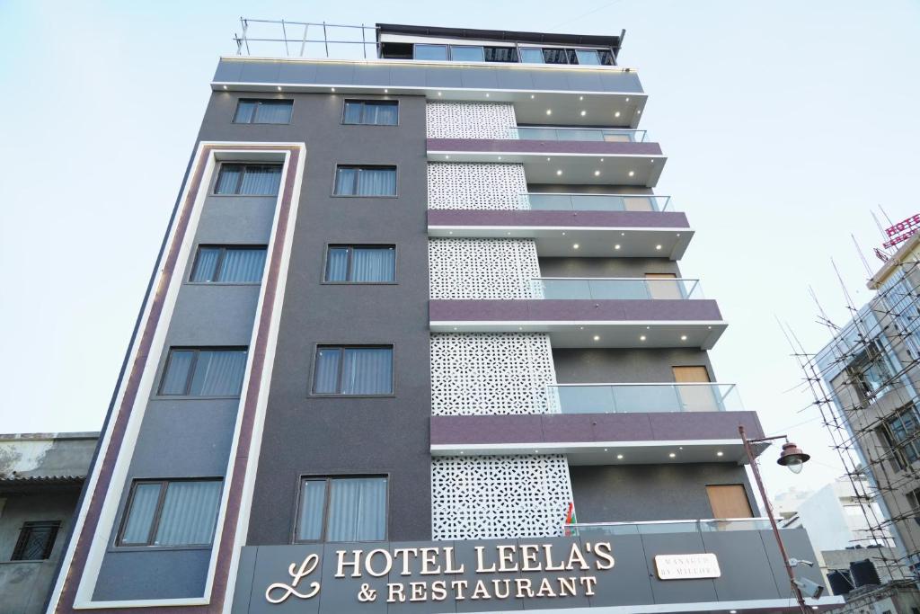 德瓦尔卡Hotel Leela's的一座前面有标志的高楼