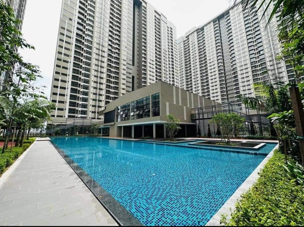 a swimming pool in front of a large building at SYG 15 Youth City Nilai Homestay 2 Bilik Tidur in Nilai