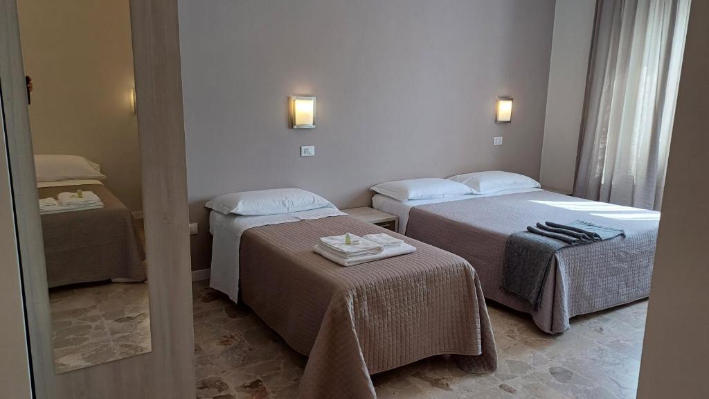 a hotel room with two beds and a mirror at B&B Monté in Montesilvano