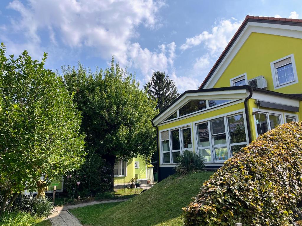żółty dom z oknami i drzewami w obiekcie AJO Apartments - Alte Donau Terrace Studio - Self-Check-in w Wiedniu