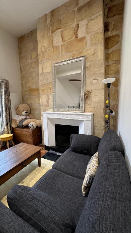 un salon avec un canapé et une cheminée dans l'établissement Le Notre-Dame - Au coeur des Chartrons, à Bordeaux