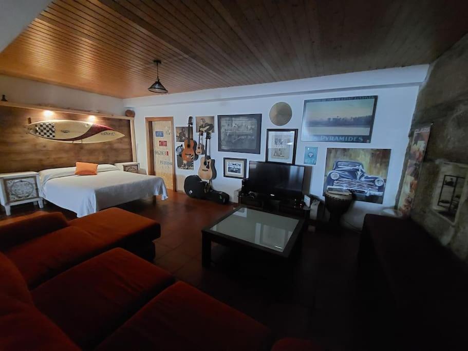 a living room with a bed and a couch at Loft Surf & Music in Gandara