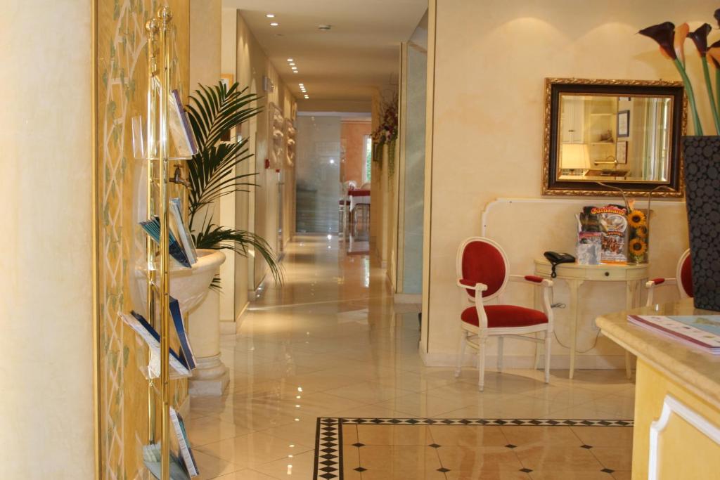 um corredor com uma cadeira vermelha numa casa em Hotel Alsazia em Sirmione