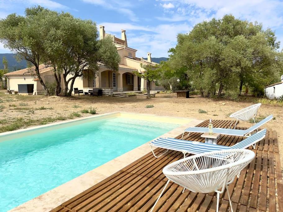 une piscine avec deux chaises longues et une maison dans l'établissement Mas Provençal Privé avec Piscine sans vis à vis en plein Cœur du Luberon, à La Motte-dʼAigues