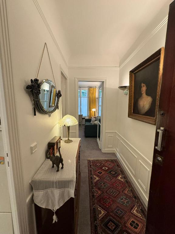 un couloir avec une table et un miroir mural dans l'établissement Luxury and cosy apartment in Paris, 16è Arrondissement, à Paris