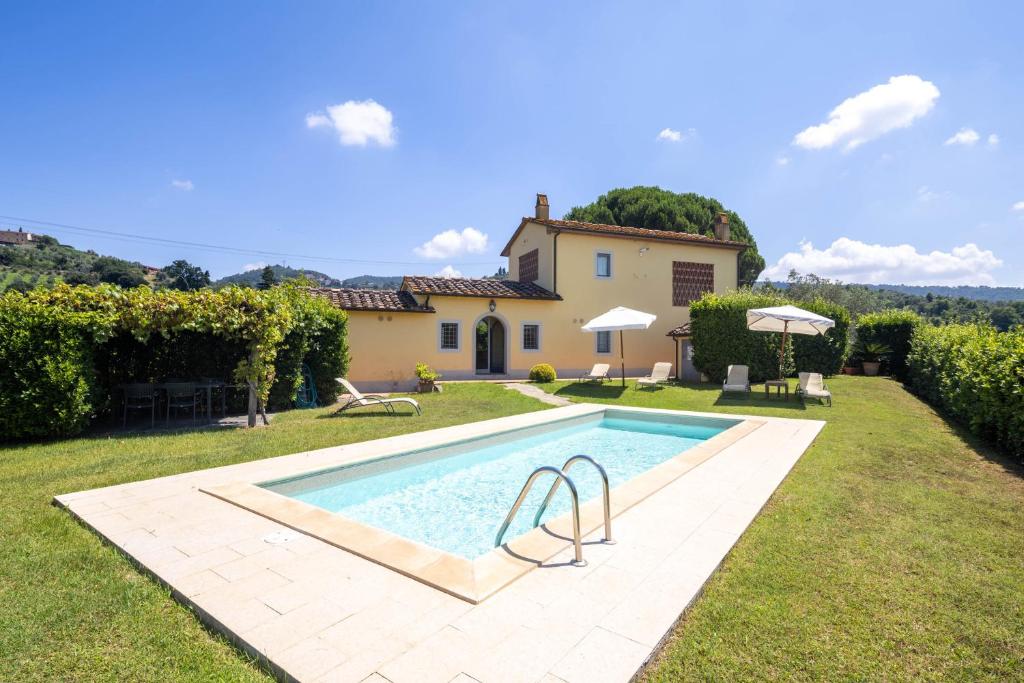 une vue extérieure d'une villa avec piscine dans l'établissement Villa il Fienile by VacaVilla, à Lamporecchio
