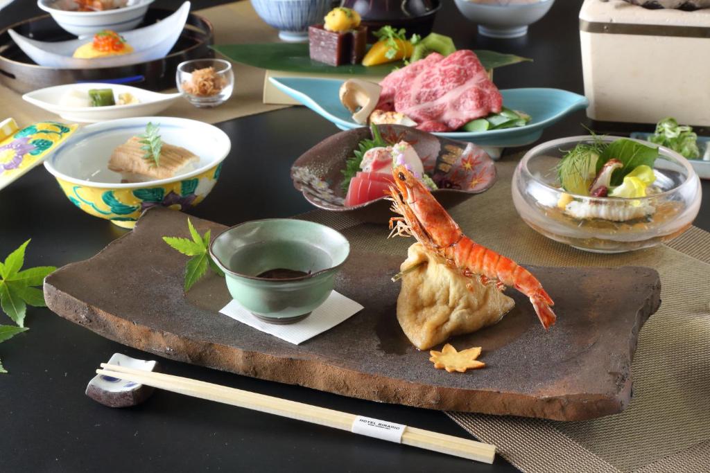 a table with a plate of food and chopsticks at Hotel Binario Saga Arashiyama in Kyoto
