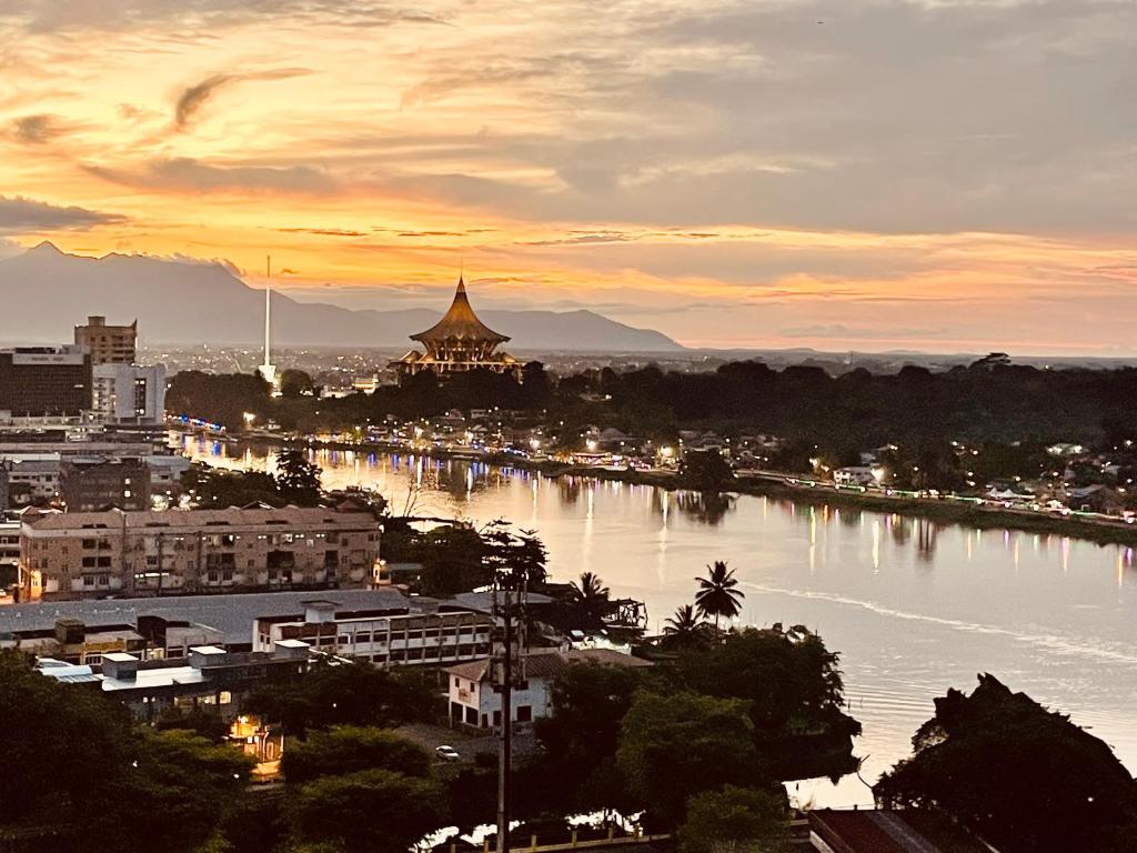 a view of a city with a river and a pagoda at Kuching City Center Riverine Apartment With Balcony and Garden View in Kuching