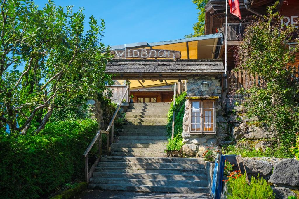 Hotel Wildbach Brienz في برينز: مجموعة من السلالم المؤدية إلى مبنى عليه لافتة