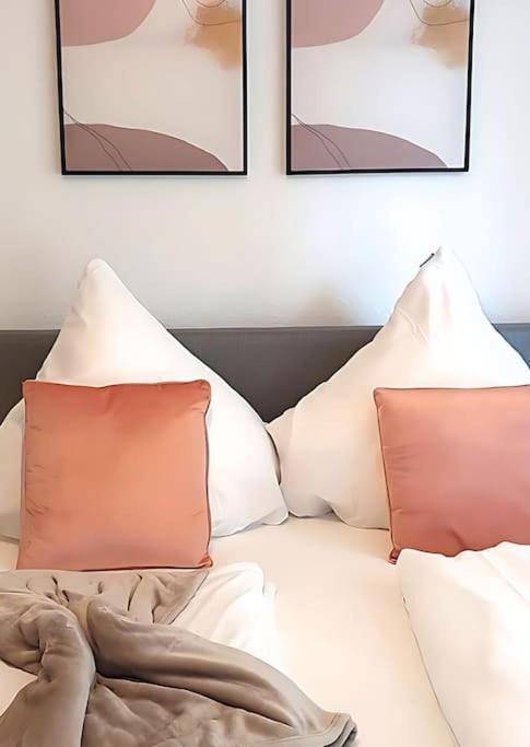 a white bed with two pillows and three pictures at Ludwigshafen-Bahnhofsresidenz in Ludwigshafen am Rhein