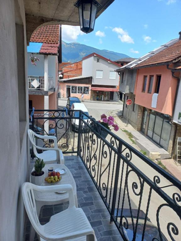 a balcony with white chairs and a table with fruit on it at Adagio Studio Apartment in Plav