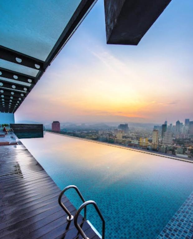 a swimming pool on top of a building with a city skyline at Celestial Heights Hostel featuring Infinity Skypool in Kuala Lumpur