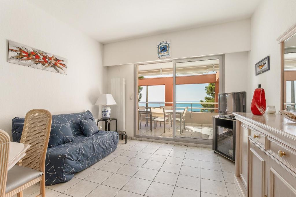 Il comprend un salon avec un canapé et une cuisine avec vue. dans l'établissement Le Domaine du Golf - Appt vue mer avec piscine, à Sète