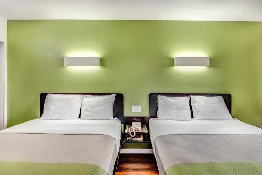 two beds in a room with green walls at Motel 6-Visalia, CA in Visalia