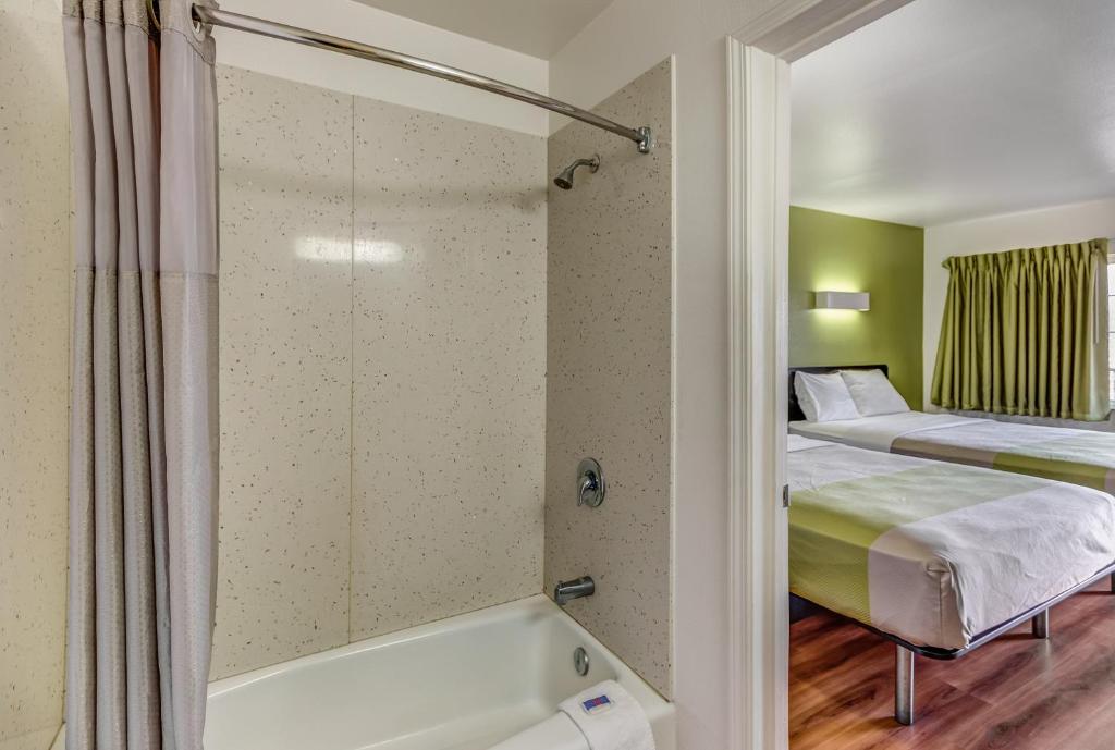 a hotel room with a bed and a bathtub at Motel 6-Visalia, CA in Visalia