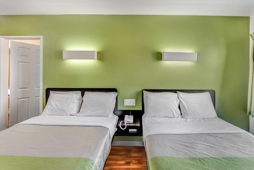 two beds in a room with green walls at Motel 6-Visalia, CA in Visalia