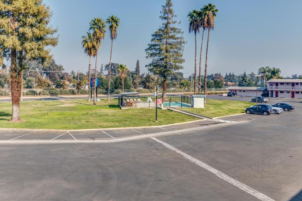 a parking lot with a basketball court and palm trees at Motel 6-Visalia, CA in Visalia