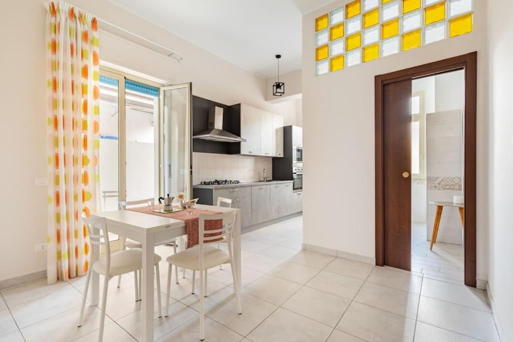 a kitchen and dining room with a table and chairs at Andiloro Home in Reggio Calabria