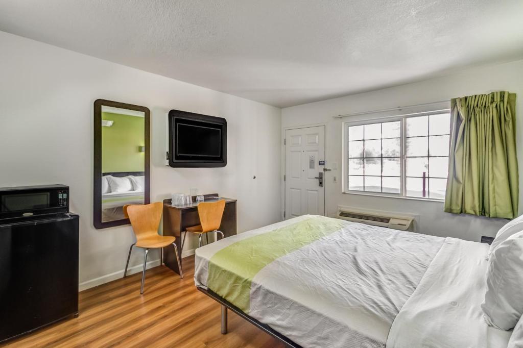 a bedroom with a bed and a desk and a television at Motel 6-Visalia, CA in Visalia