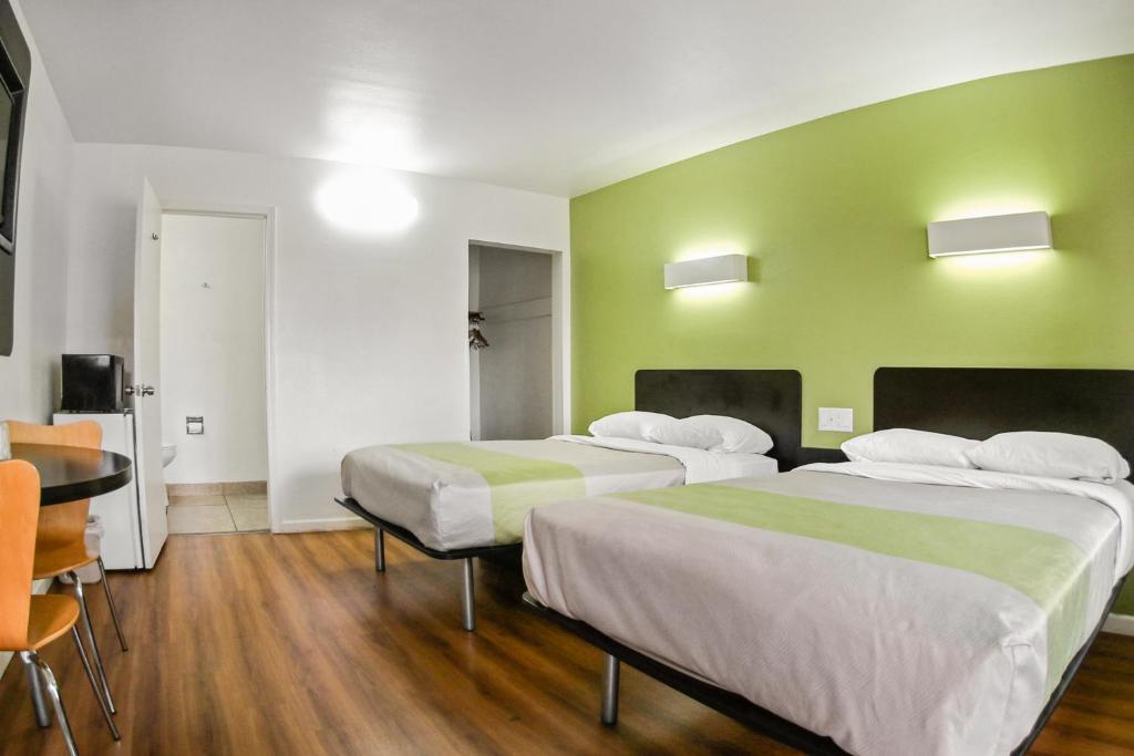 two beds in a room with green walls at Motel 6-Visalia, CA in Visalia