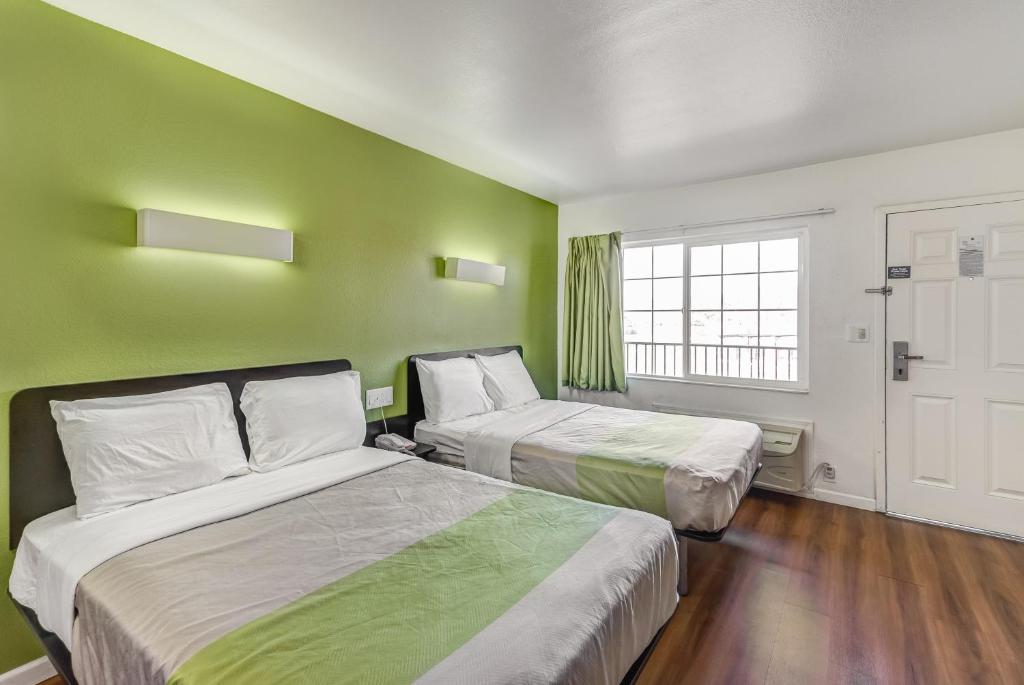 two beds in a room with green walls at Motel 6-Visalia, CA in Visalia
