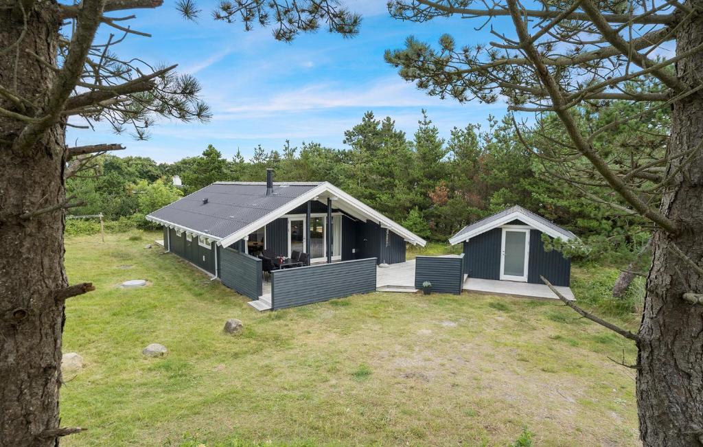 a small blue house in the middle of a yard at Amazing Home In Hvide Sande With Wifi in Bjerregård
