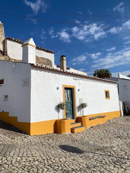 a white building with a door on the side of it at Olive Tree House in Terena