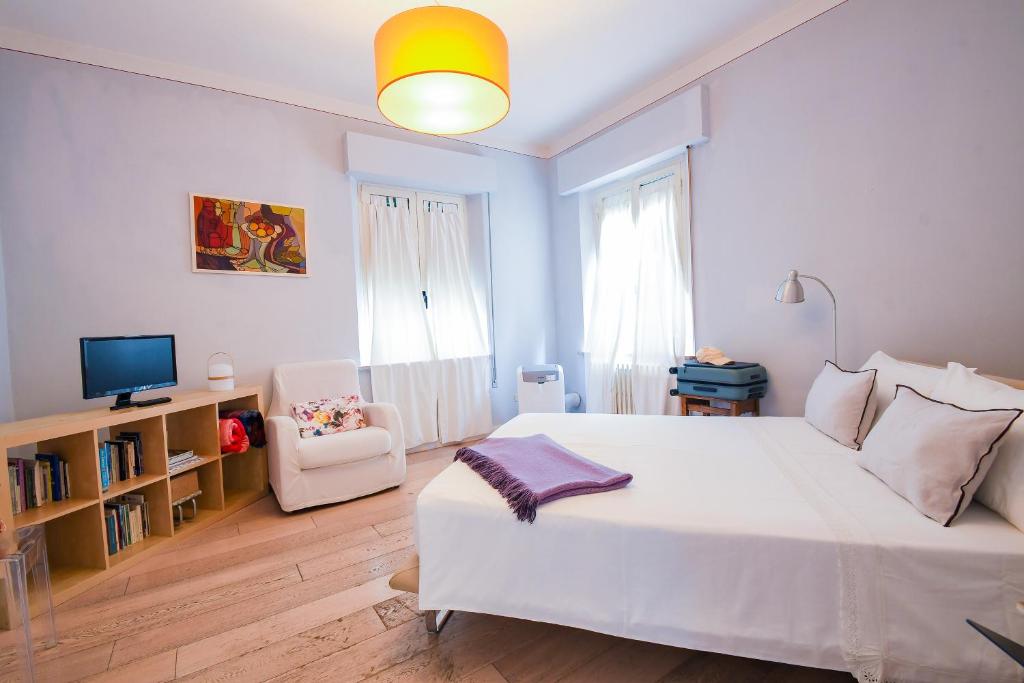 a bedroom with a large white bed and a chair at Belle Viste - Boutique Apartments in Bettolle