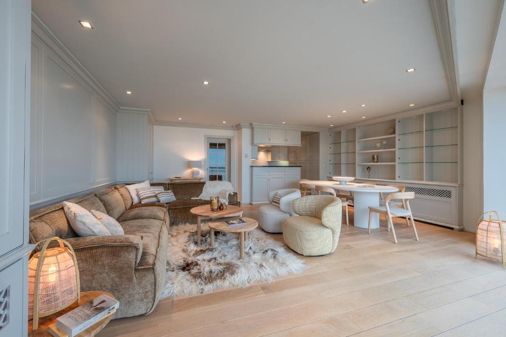 a living room with a couch and a kitchen at 3e verdiep 3-slaapkamer appartement op de zeedijk in hartje Knokke voor 7 personen in Knokke-Heist