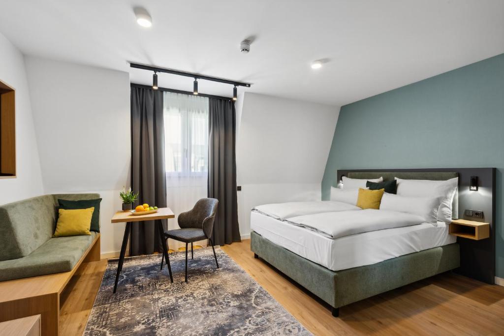 a bedroom with a bed and a couch at Nena Apartments München City in Munich