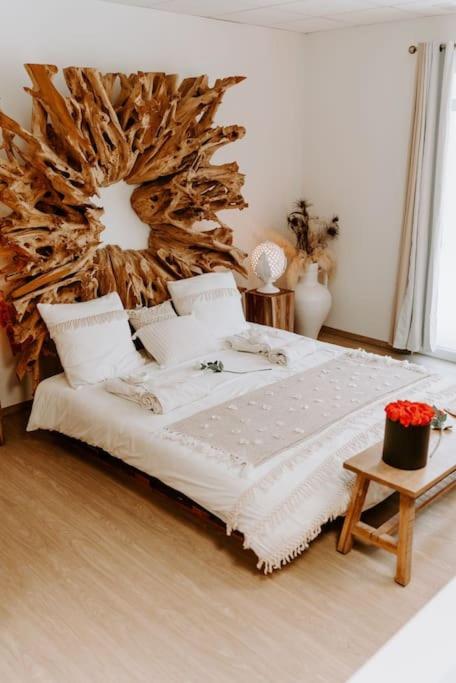a bedroom with a large bed with a wooden headboard at Suite de charme avec jacuzzi et cabine infrarouge in Tubize