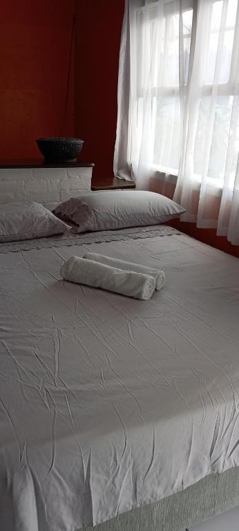 a white bed with a pillow on top of it at Suíte para a Oktoberfest in Blumenau