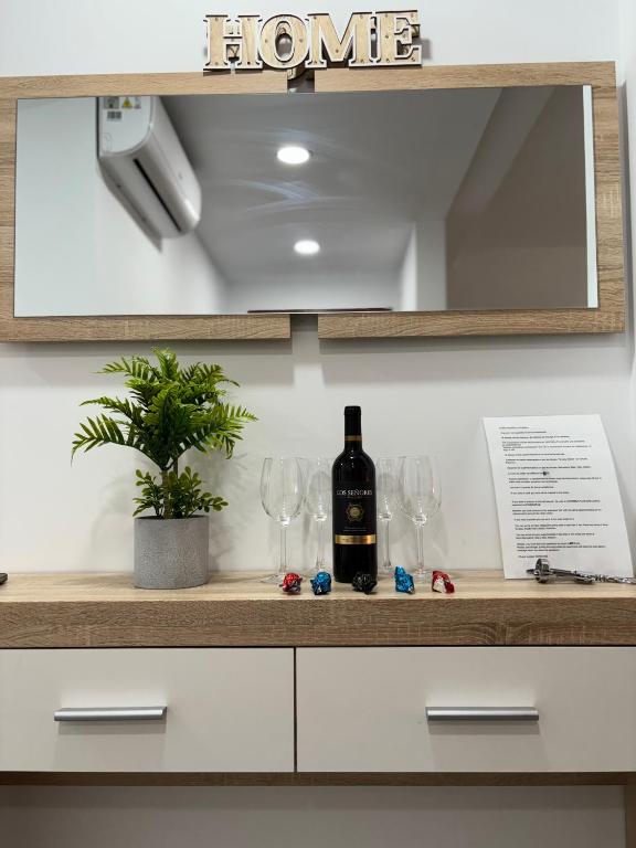 a bottle of wine sitting on a counter with wine glasses at Apart LA PLANA II in Castellón de la Plana