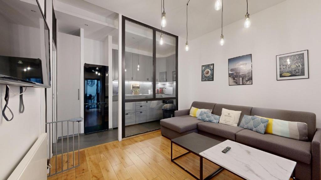 un salon avec un canapé et une table dans l'établissement Bluestay 6 - Superbe appartement à Paris, à Paris