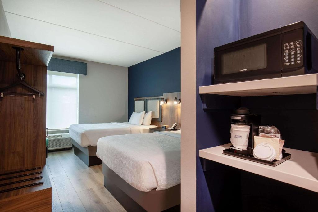 a hotel room with two beds and a microwave at La Quinta Inn & Suites by Wyndham Chattanooga Downtown/South in Chattanooga