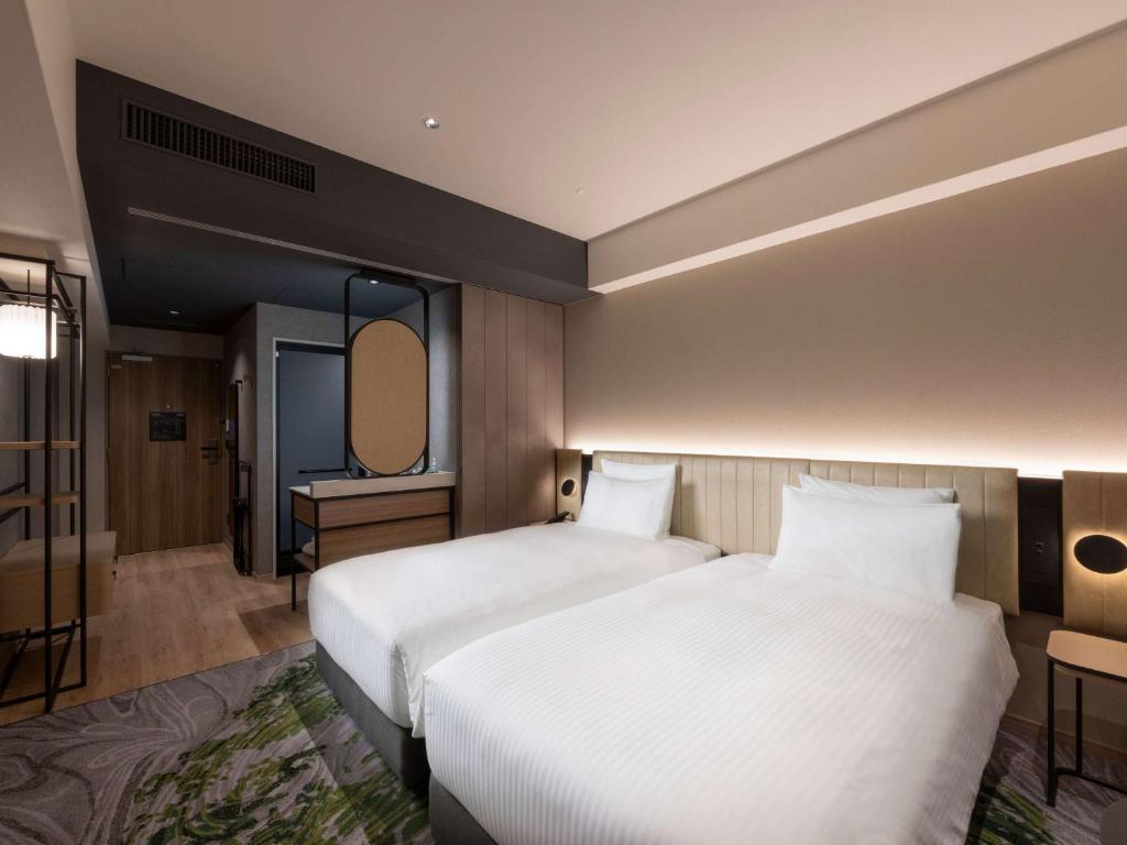 a hotel room with a bed and a mirror at Novotel Nara in Nara