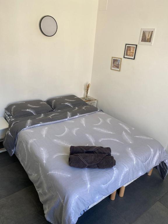 - un lit blanc avec une serviette dans la chambre dans l'établissement Studio Colombes fonctionnel, à Colombes