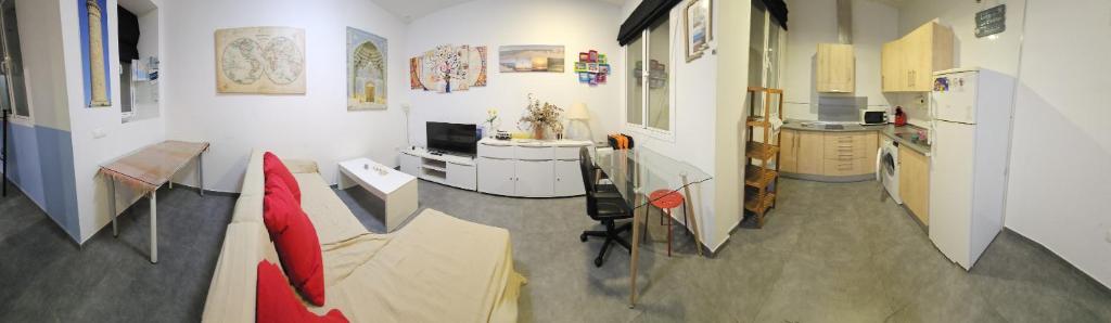 uma cozinha com uma cadeira vermelha e uma mesa em Sopranis del MAR Apartamento centro Cádiz, junto playa y estación em Cádis