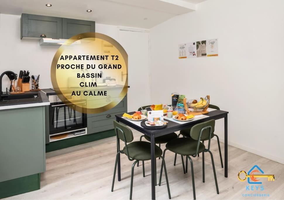 - une table noire avec des chaises dans la cuisine dans l'établissement L'abreuvoir cosy proche grand bassin avec clim, à Castelnaudary