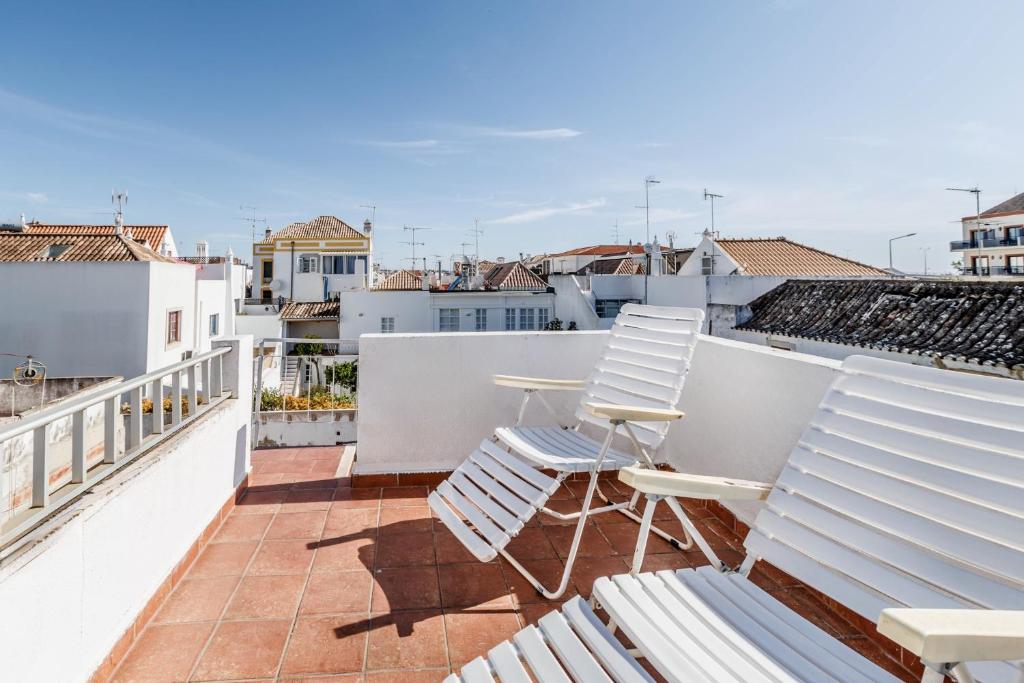 a patio with two chairs and a table on a balcony at Casa Delgado in Tavira