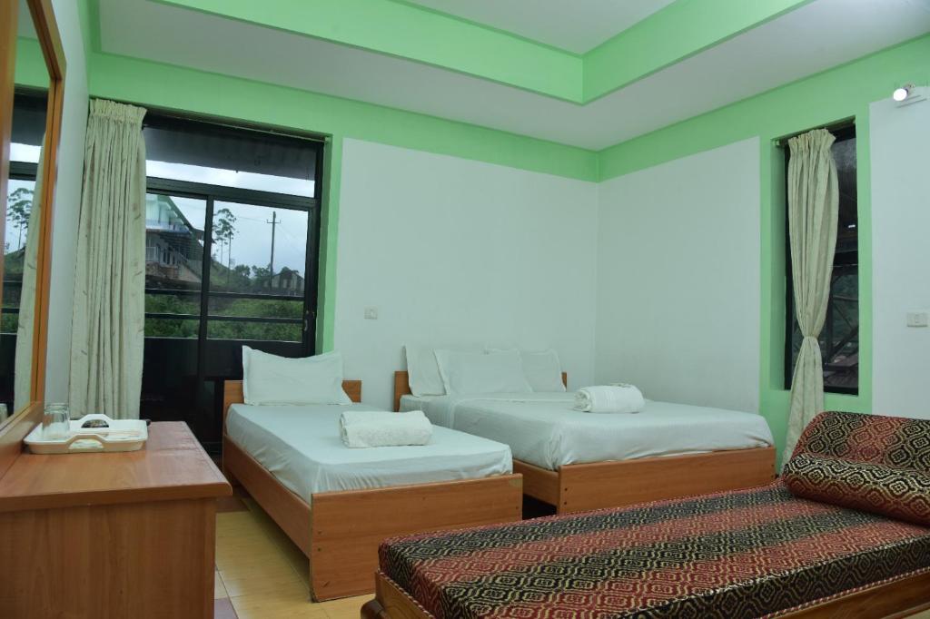 Postel nebo postele na pokoji v ubytování Raahath Inn Munnar